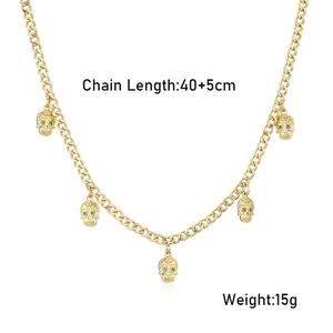 Collier plaqué or style hip hop avec cinq pendentifs crânes et yeux en cristaux verts