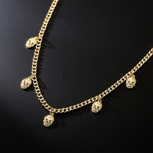 Collier hip-hop doré avec chaîne cubaine, cinq pendentifs têtes de mort et yeux verts