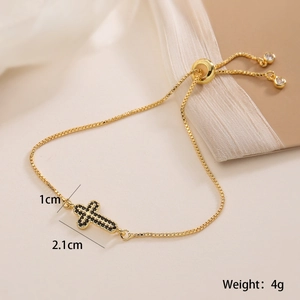 Détail du bracelet croix plaqué or 18K avec zircon noir et fermoir réglable coulissant