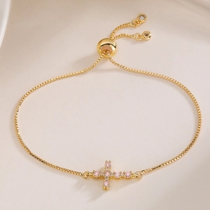 Detail of 18K gold plated cross bracelet with pink zircon stones and adjustable slide clasp
