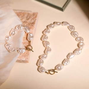Baroque pearl necklace and bracelet set with gold OT clasp on elegant marble background