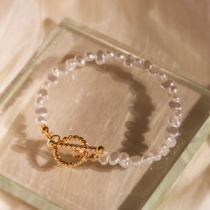 Baroque irregular pearl bracelet with gold textured OT toggle clasp on champagne silk fabric