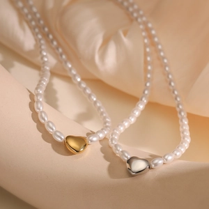 Elegant 18K gold and silver plated heart pearl necklaces on luxury silk background