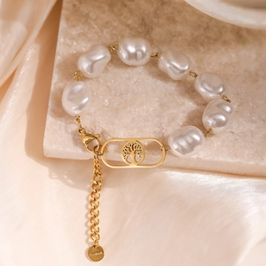 Baroque pearl bracelet with gold Tree of Life pendant on textured silk background