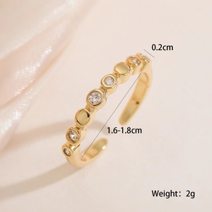 Detail shot of 18K gold plated ring with zircons and beads on silk background