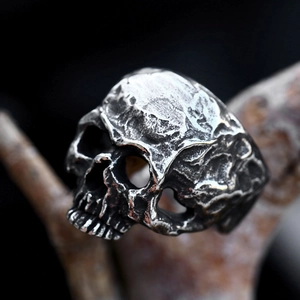 Vintage stainless steel skull ring with realistic carvings and gothic finish on wood