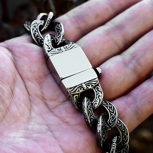 Detail of vintage stainless steel chain bracelet featuring Celtic knot embossed patterns