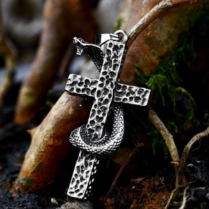 Gothic vintage stainless steel cross pendant with detailed coiled snake on mossy wood