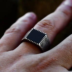 Macro shot of men's vintage stainless steel signet ring with a black rectangular inlay