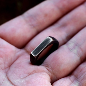 Detailopname van een minimalistische ring van geborsteld roestvrij staal met retro-afwerking