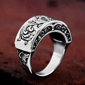Detailed macro view of vintage stainless steel signet ring with baroque floral engraving