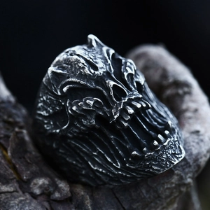 Anillo de calavera punk vintage de acero inoxidable con texturas góticas sobre madera