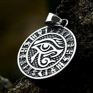 Detailed close-up of vintage Eye of Horus steel pendant on dark textured rock