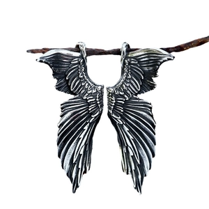 Vintage stainless steel angel wing pendant with gothic feather texture on a branch