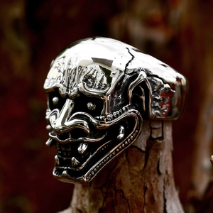 Polished stainless steel Hannya mask skull ring in punk style shown on wood background