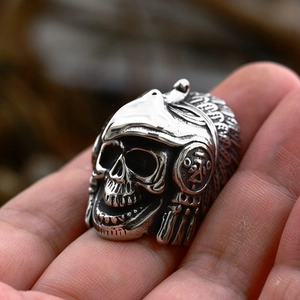 Detailed view of hand-held vintage stainless steel skull ring with eagle feather headdress
