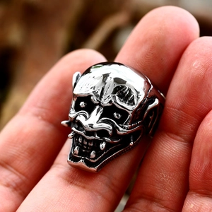 Detailed macro view of silver Hannya mask ring with intricate punk skull textures
