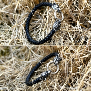 Detail of woven leather bracelet with dual wolf heads and metal ring in vintage style