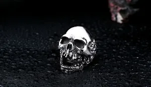 Macro shot of silver stainless steel skull ring showing detailed gothic bone textures