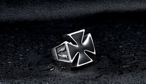 Macro view of vintage stainless steel ring with black iron cross and lightning relief