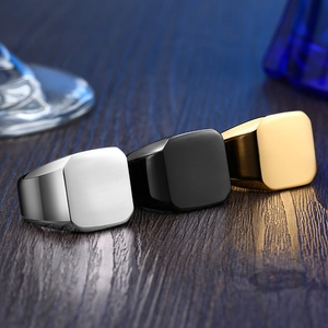 Minimalist square signet rings in silver, black, and gold on dark wood surface
