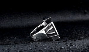 Detailed view of stainless steel lightning bolt ring on black leather with water drops