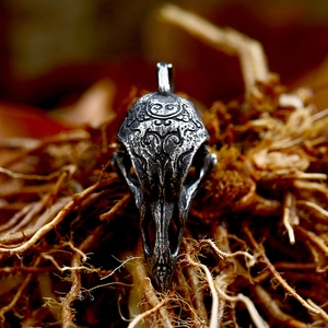 Macro shot of a Viking raven skull pendant with ornate carvings in vintage stainless steel