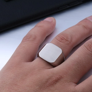 Macro shot of men's matte brushed stainless steel signet ring with a flat square top