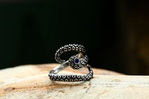 Macro detail of octopus tentacle ring with blue gemstone and vintage silver texture
