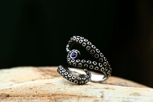 Macro shot of vintage steel octopus ring with suction cup texture and blue gemstone