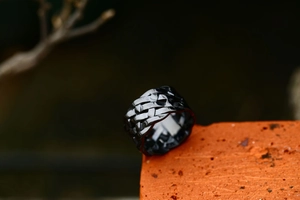 Macro detail of black stainless steel Viking knot ring with intricate woven texture finish