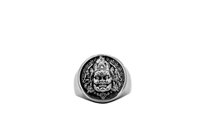 Macro view of vintage stainless steel ring with intricate guardian deity mask relief