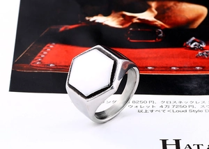 Detail shot of a men's hexagonal stainless steel signet ring with white enamel inlay