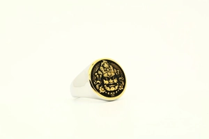 Macro view of vintage titanium steel ring with gold relief Buddha mask and geometric carving
