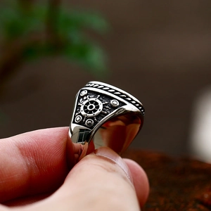 Primer plano de un anillo pirata de acero inoxidable con detalle de timón en relieve
