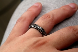 Close-up of a vintage punk skull ring in silver stainless steel on a model's finger