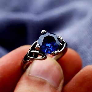 Retro stainless steel ring featuring a large round blue gemstone and Celtic knot design