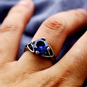 Vintage stainless steel ring featuring a round blue gemstone and hollow geometric patterns