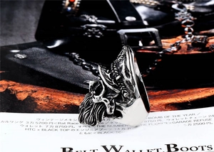 Detail of vintage silver skull ring with navy hat on magazine with leather belt