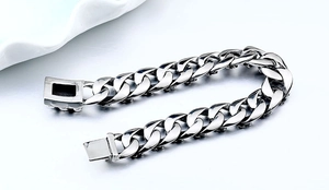 Détail macro du bracelet à mailles cubaines en acier poli avec un fermoir boîte carré
