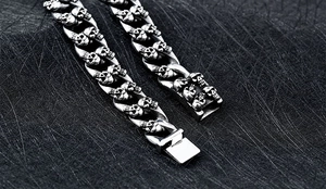 Détails macro de gravures de crânes gothiques sur un bracelet à maillons épais en acier