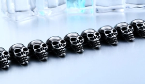Close-up of punk style stainless steel skull link bracelet with detailed engraving