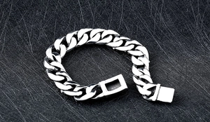 Détail du bracelet gourmette en acier inoxydable argenté avec fermoir boîte sur fond noir