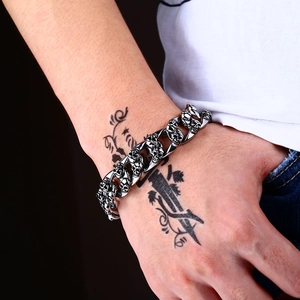 Bracelet punk pour homme en acier inoxydable avec crânes sur poignet tatoué
