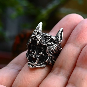 Close-up of a vintage stainless steel wolf head ring with a skull inside the mouth