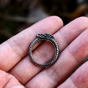 Detailed macro view of retro stainless steel dragon scale ring on a person's palm