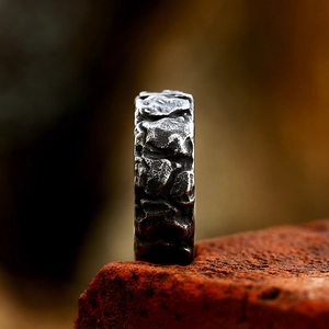 Macro view of wide vintage Viking ring with a rugged volcanic rock texture finish
