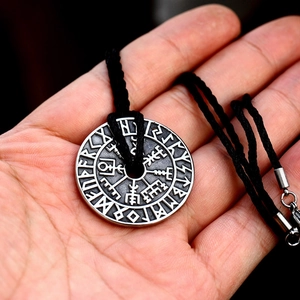 Detail of vintage silver Viking Vegvisir compass pendant with Nordic runes on woven cord