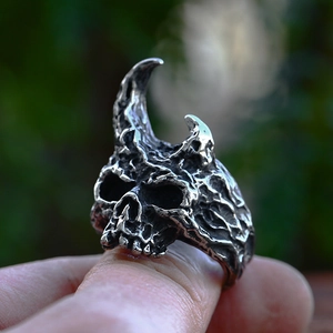 Macro shot of vintage punk skull ring with ram horns made of aged stainless steel
