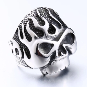 Macro view of a stainless steel skull ring with flame patterns and punk aesthetic
